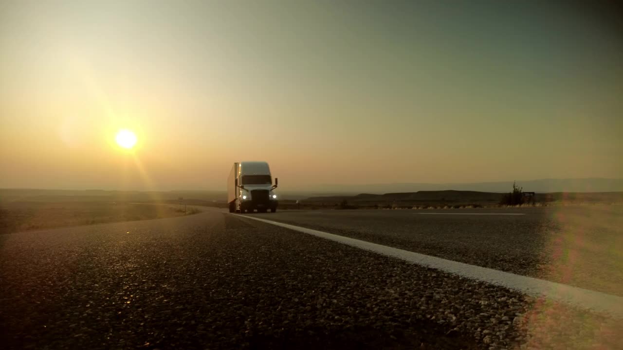 地面日落货物运输长途半挂车在美国西部州际公路乡村时间推移视频视频素材