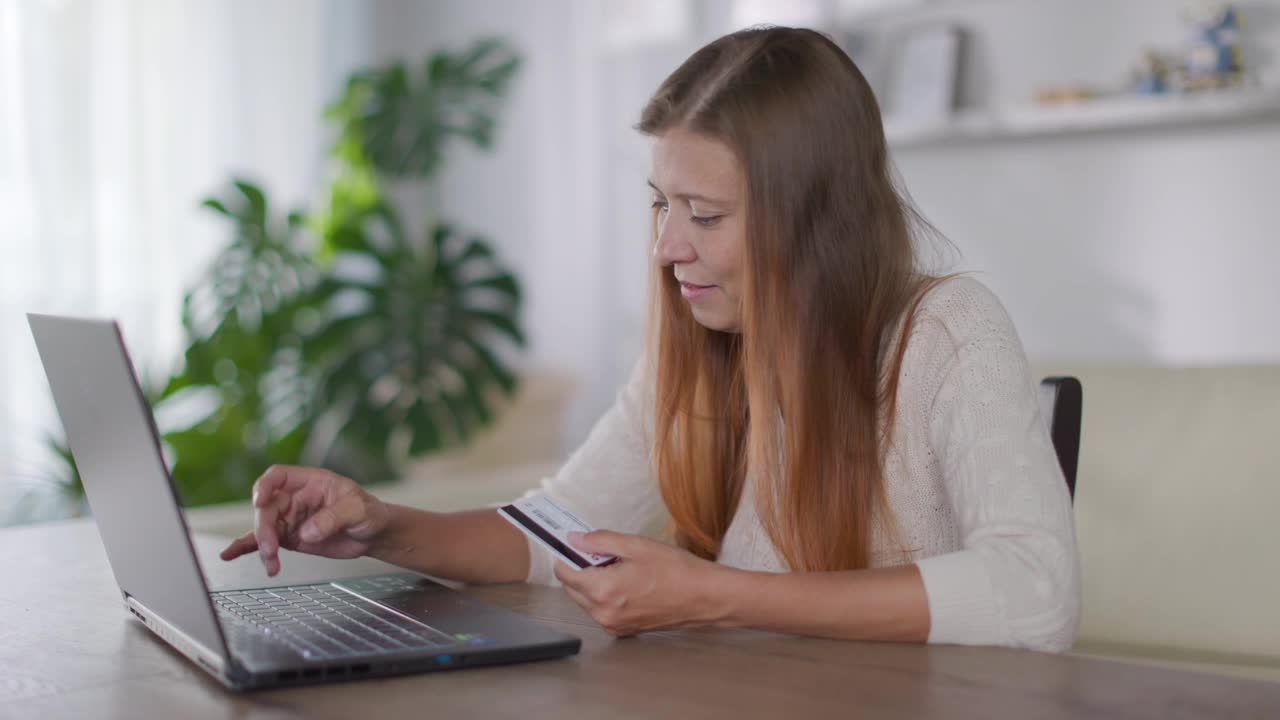 漂亮的红头发的成年女人在家里工作笔记本电脑视频下载