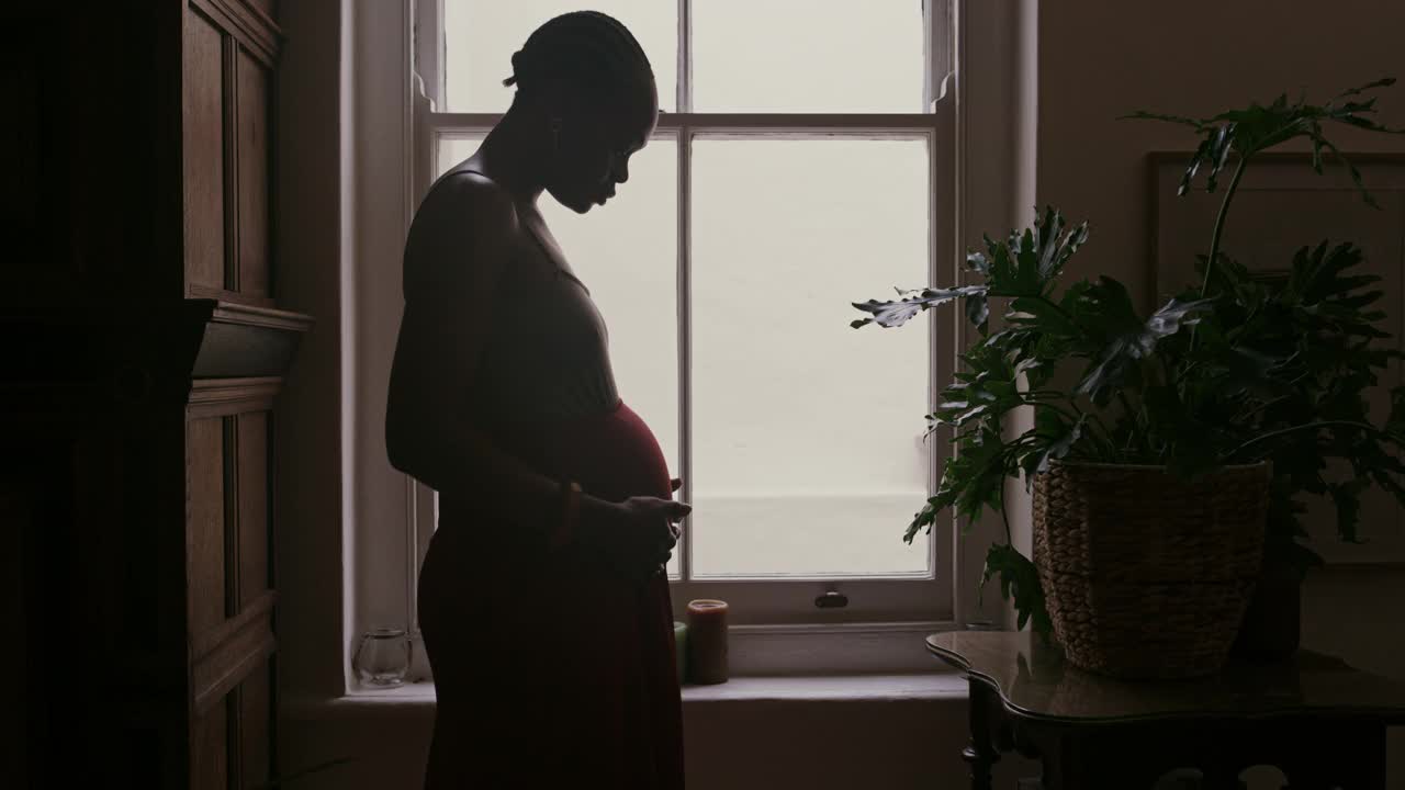 一段4k视频记录了一名怀孕女性在家摸肚子和看窗外的情景视频下载