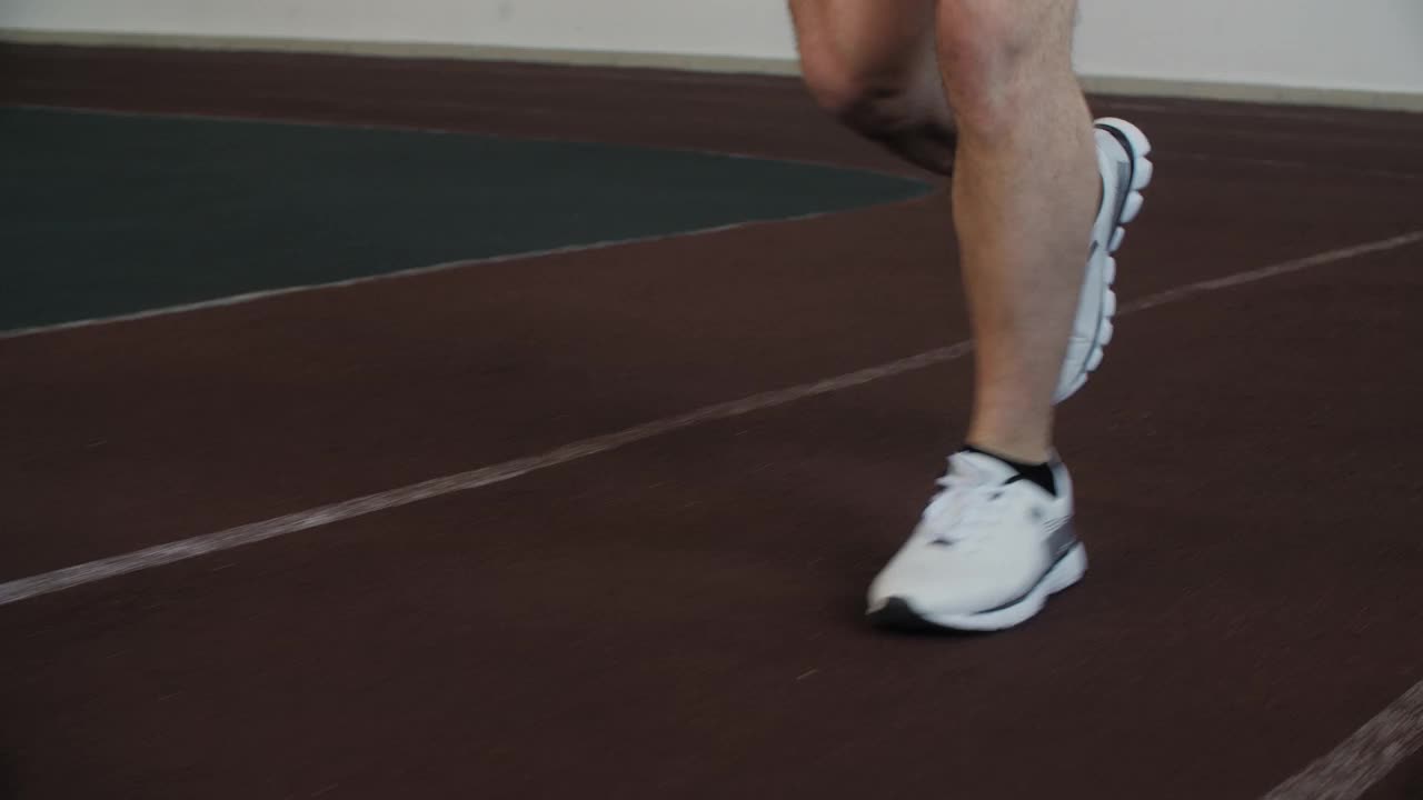 低段男子穿着运动鞋在体育场慢跑视频素材
