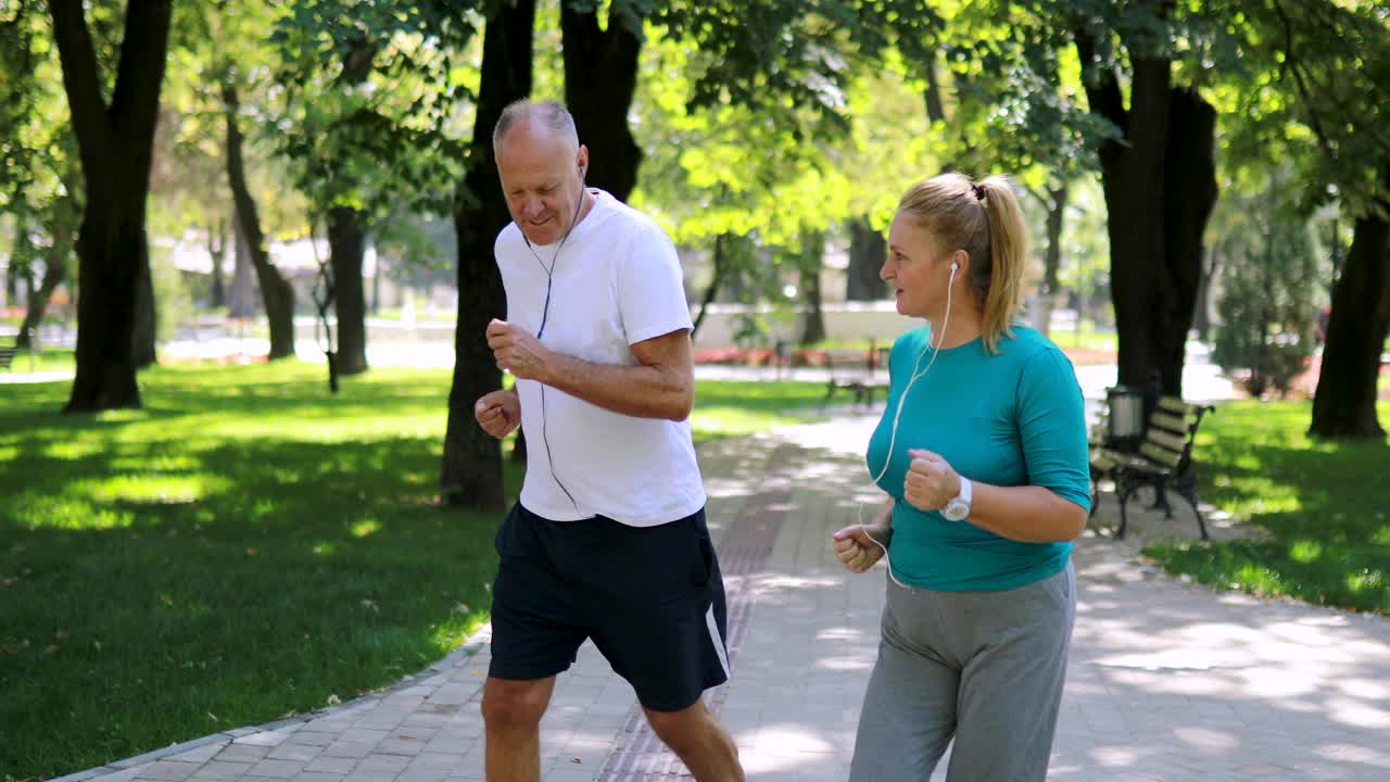 一对成熟的情侣在公园里慢跑视频素材