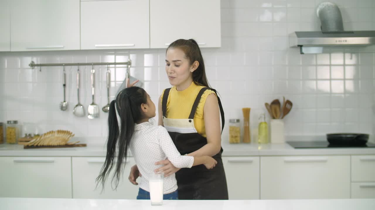 年轻的单身妈妈和女儿在一起，喝着牛奶视频下载