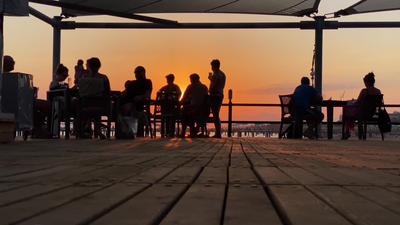 人们欣赏海上的日落。视频下载
