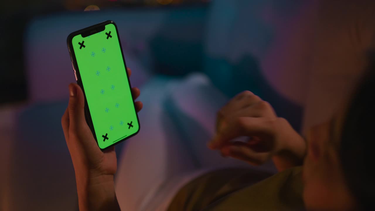 女人晚上用綠色的手機屏幕視頻素材