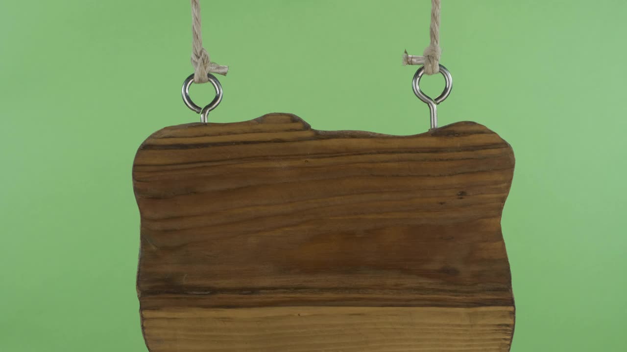 挂在绳子上的旧木牌全景图。隔离在绿色背景上视频素材