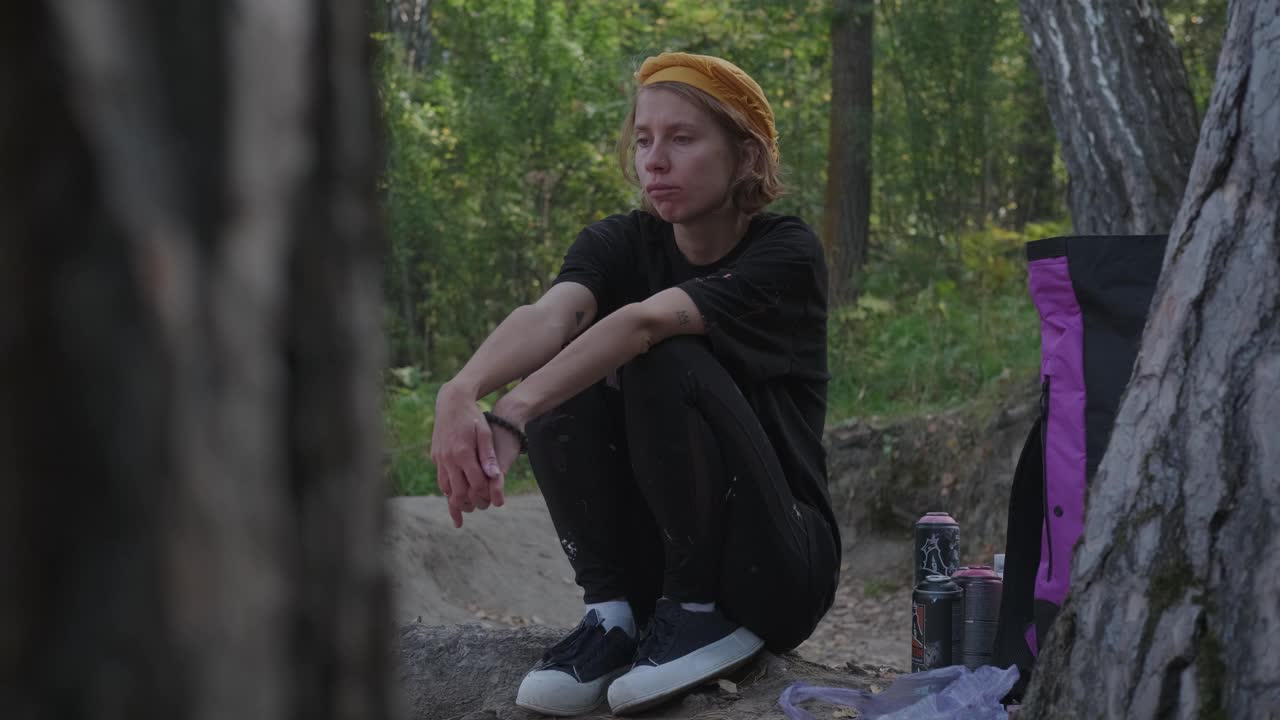 一个有创造力的女孩独自坐在画布前在森林里作画视频下载
