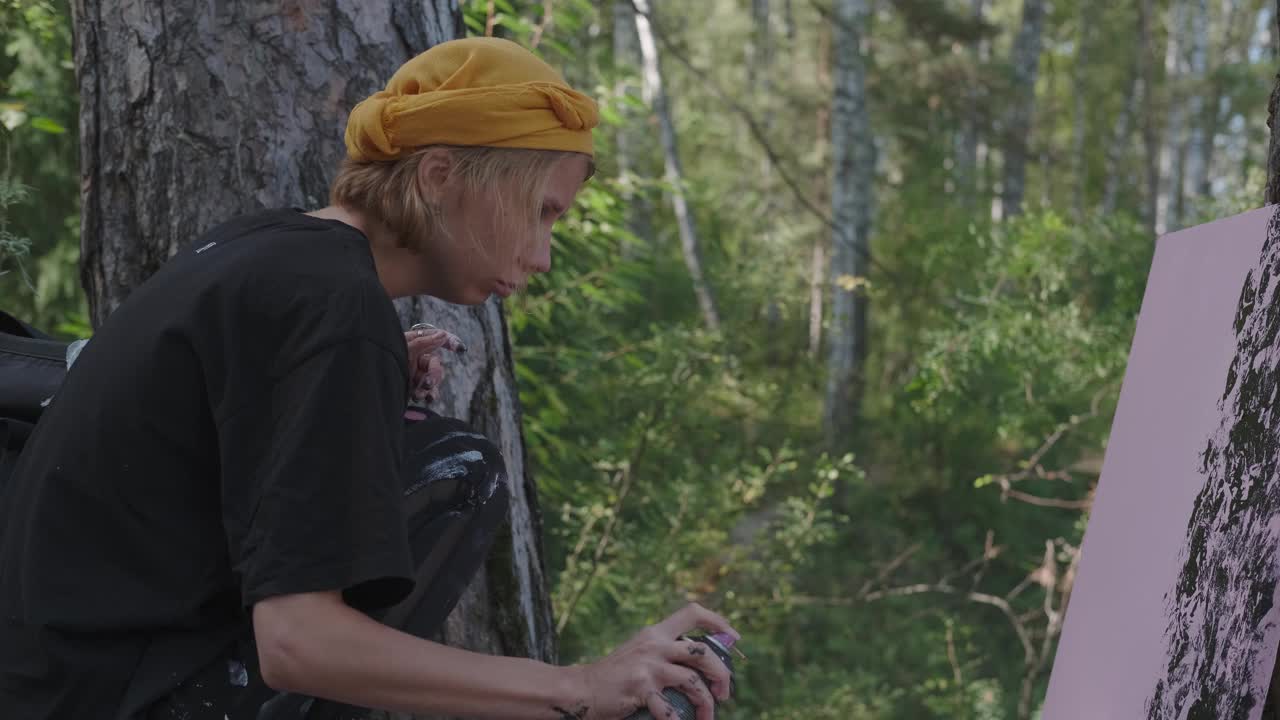 一个披着亮黄色披肩的富有创造力的女孩正在森林里画画。视频下载