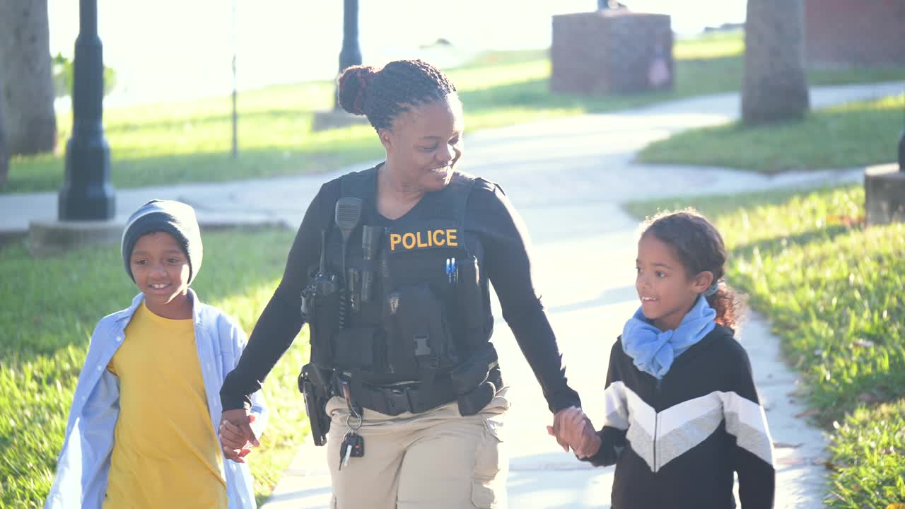社区里的女警察，带着两个孩子散步视频下载
