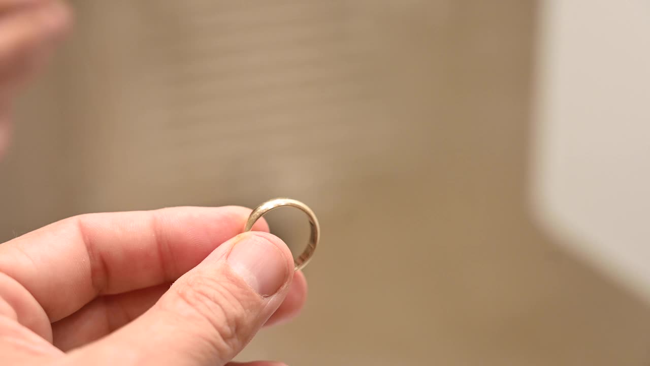 一个男人手里拿着一枚结婚戒指。视频下载