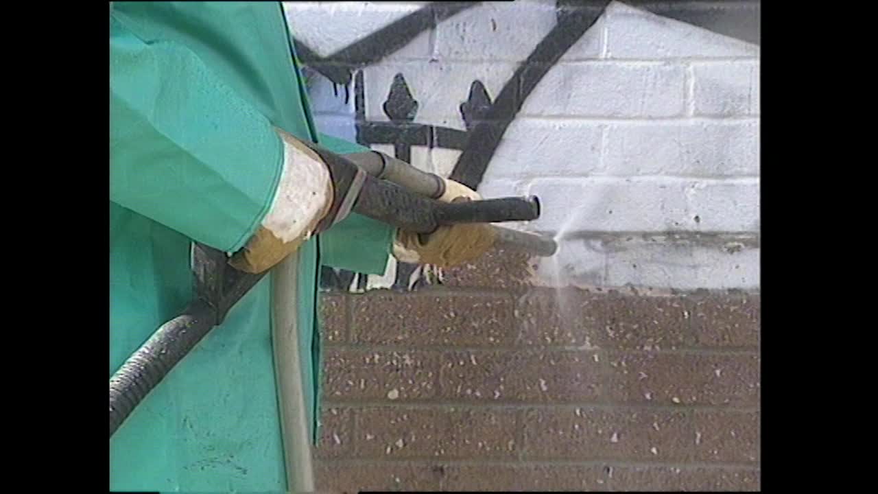 穿工作服的人加压冲洗墙壁以清除涂鸦;1994视频素材