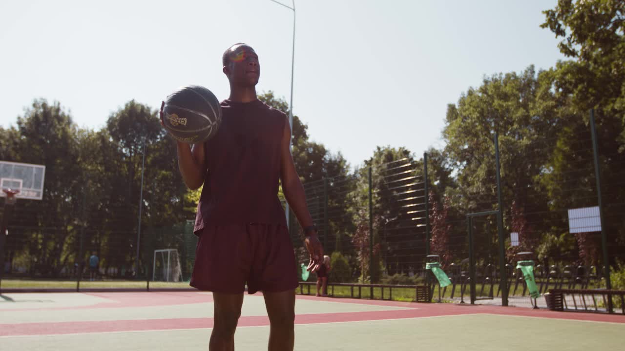 篮球运动。年轻的非裔美国人穿着制服在户外打街球，独自训练视频素材
