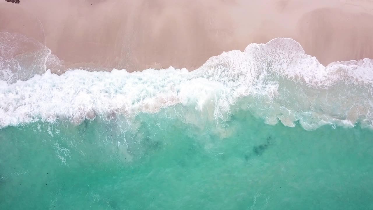 鸟瞰图热带海滩和波浪与白色的沙滩和蓝色的大海视频素材