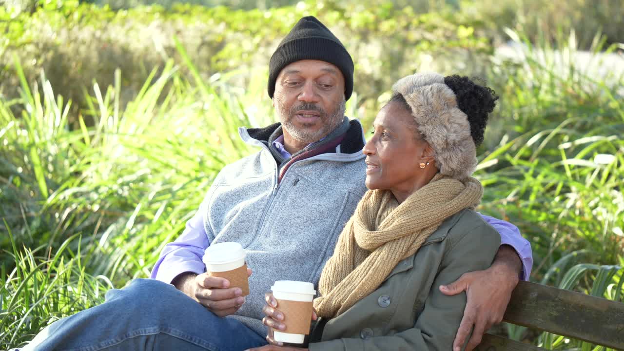 非裔美国夫妇在公园长椅上休息，喝咖啡视频下载