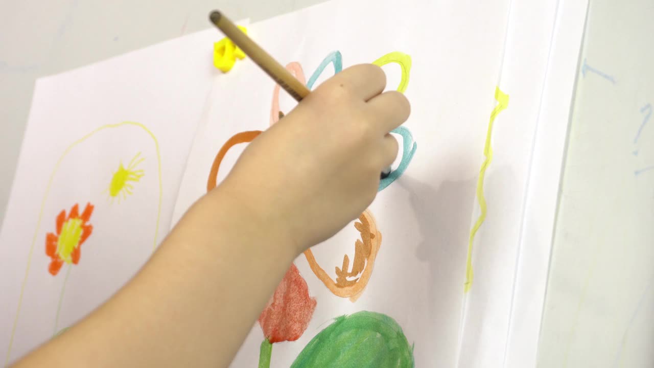 孩子们在画架上用水彩手绘花朵。学前教育、绘画课。视频下载