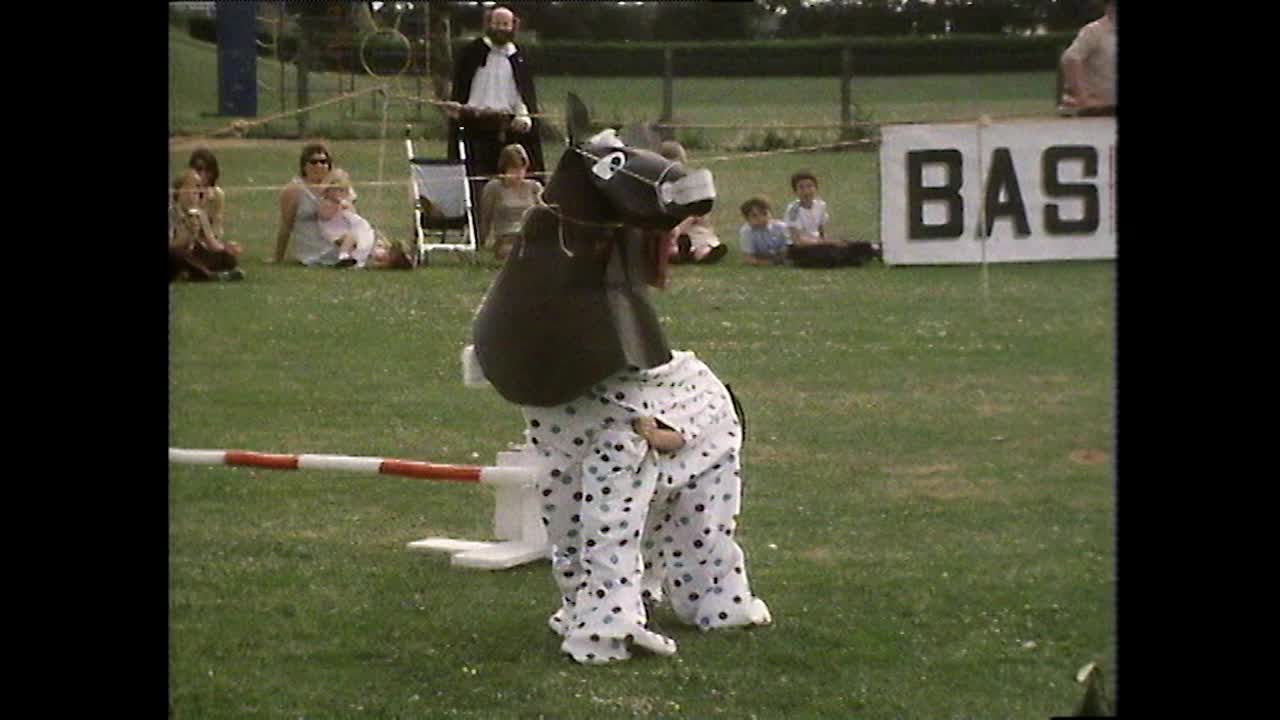 孩子们在斑点的哑剧马服装跨越表演跳跃;1980视频下载