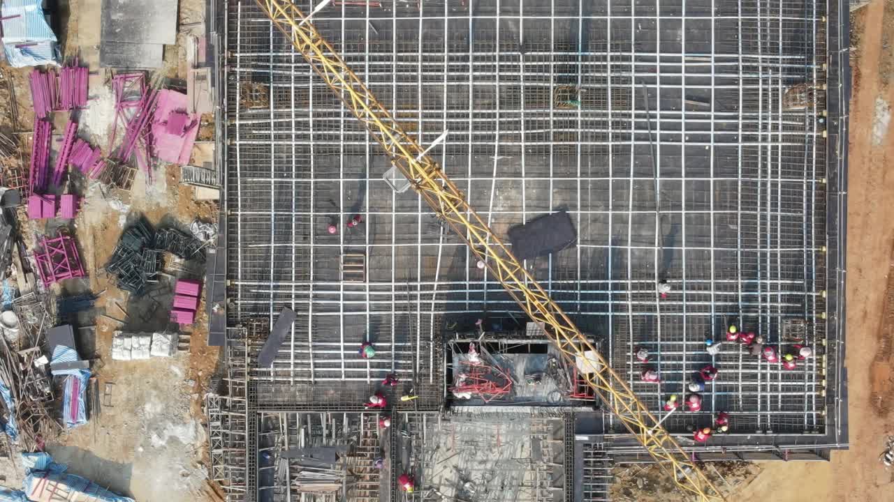 在建筑工地，起重机正在工作，工人们正在屋顶上工作。视频下载