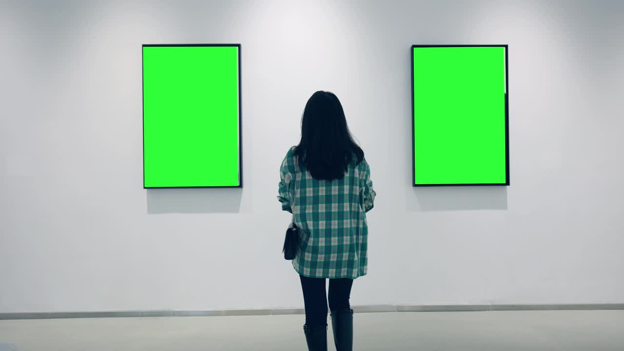 一个年轻的女人在画廊里看绿色的镜框视频下载