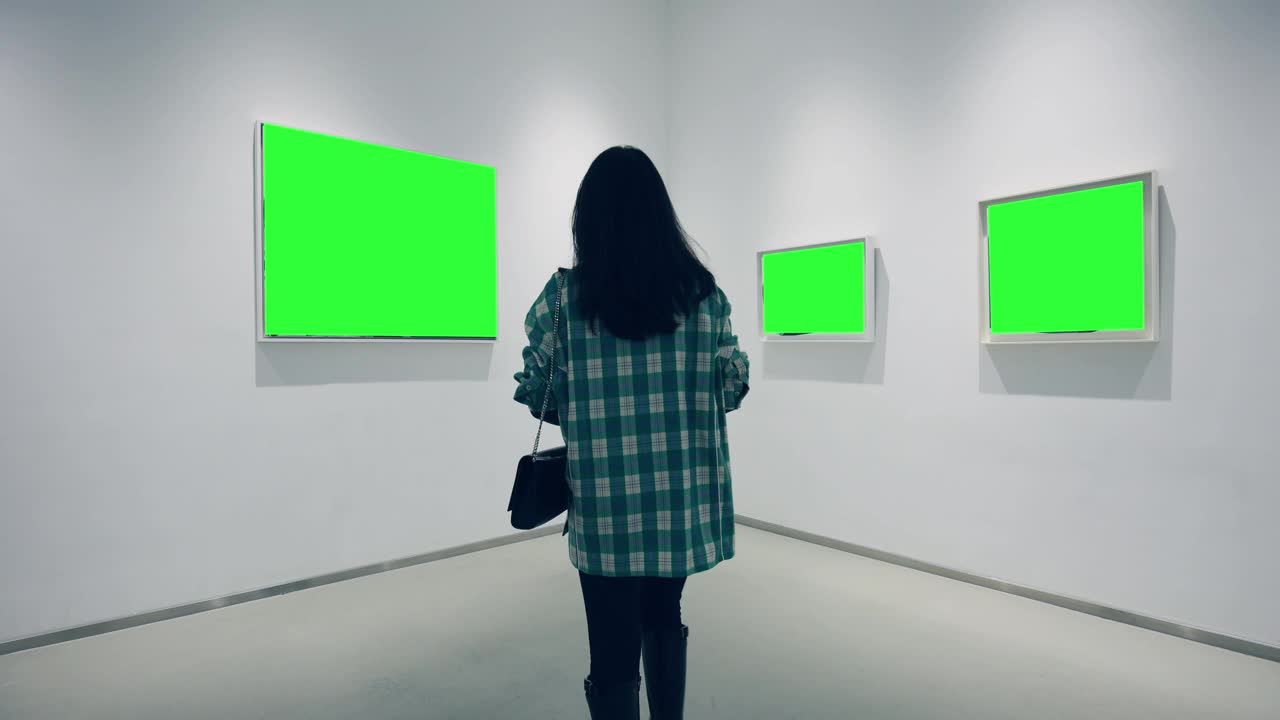 一个年轻的女人在画廊里看绿色的镜框视频下载