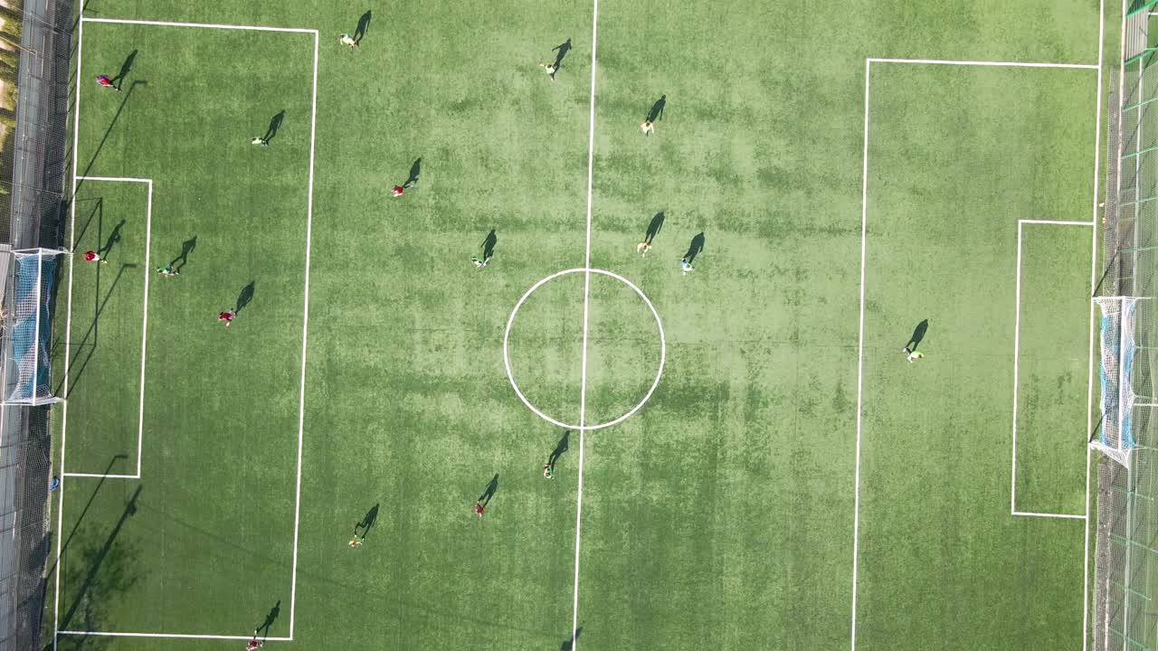 足球运动员在绿色体育场踢足球的鸟瞰图视频素材