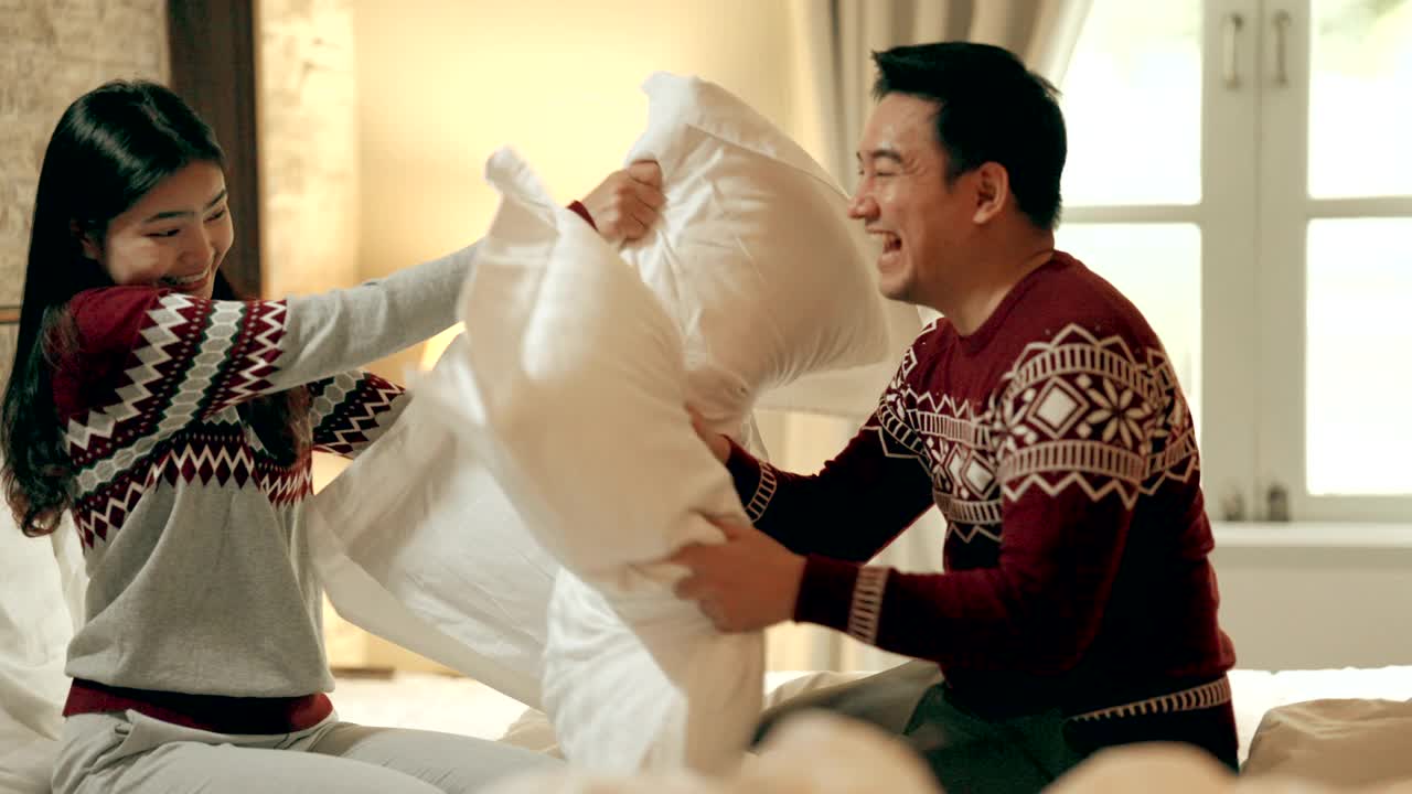 夫妻在床上枕头大战在节日庆祝圣诞季节视频素材