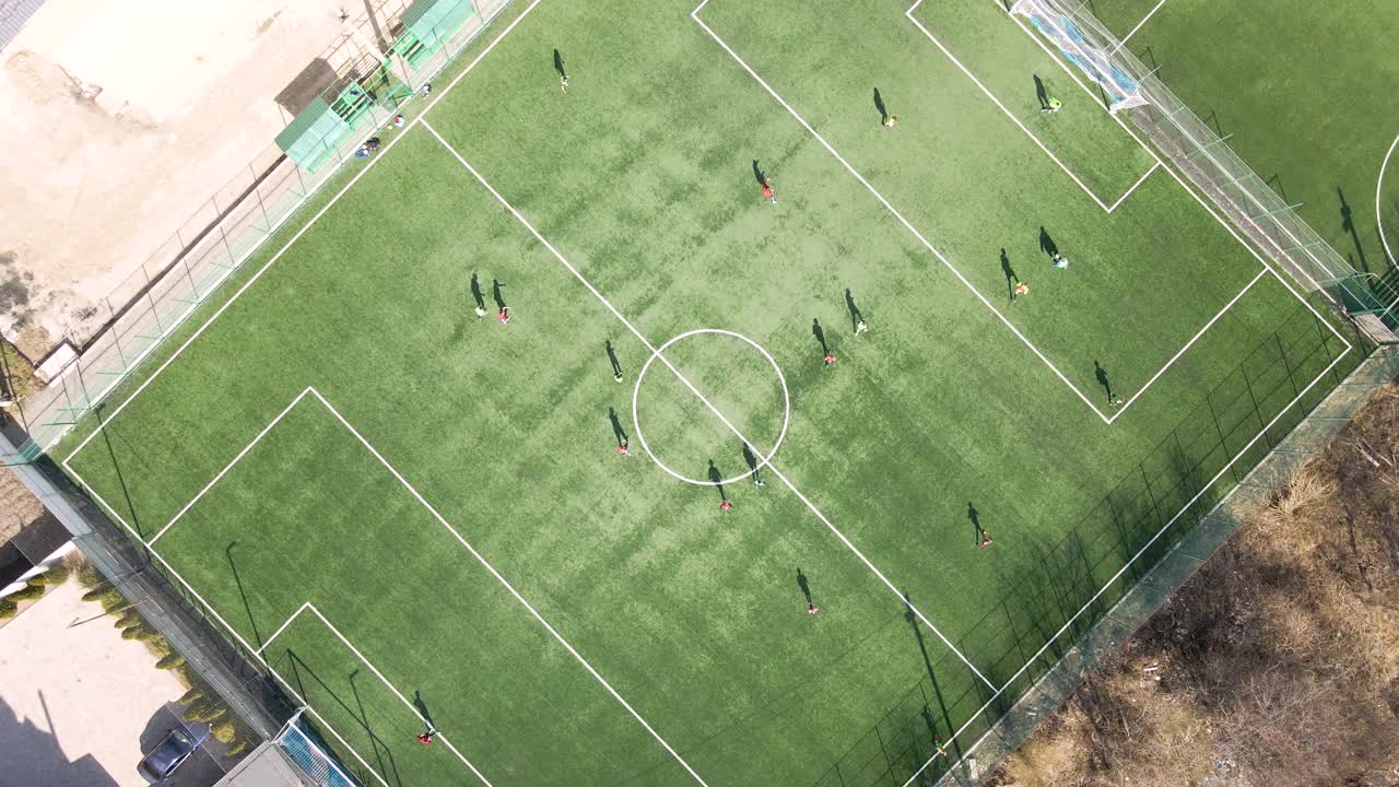 足球运动员在绿色体育场踢足球的鸟瞰图视频素材