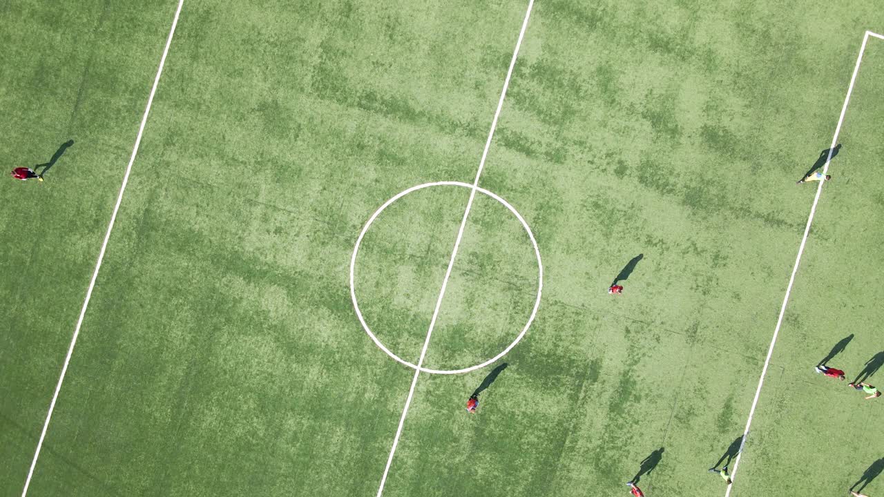足球运动员在绿色体育场踢足球的鸟瞰图视频购买