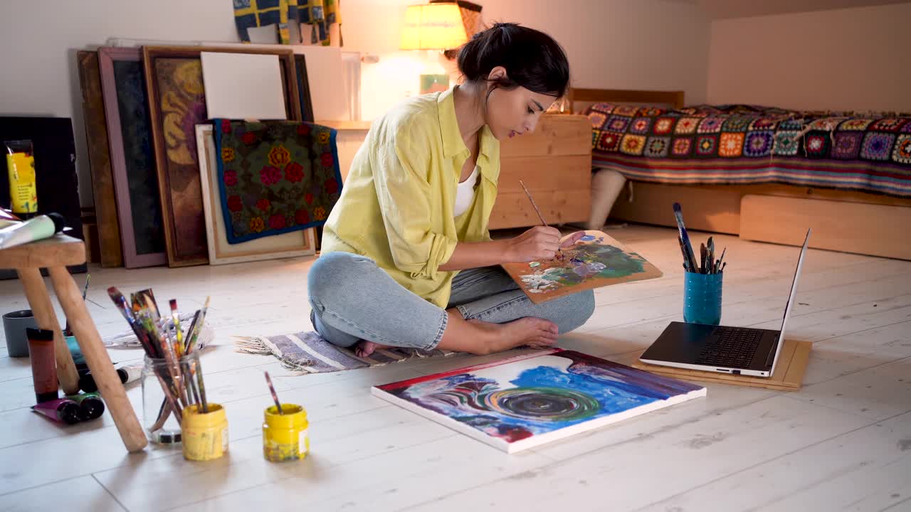 致力于女性艺术家为了学习新的绘画技术看在线教程在她的笔记本电脑视频下载