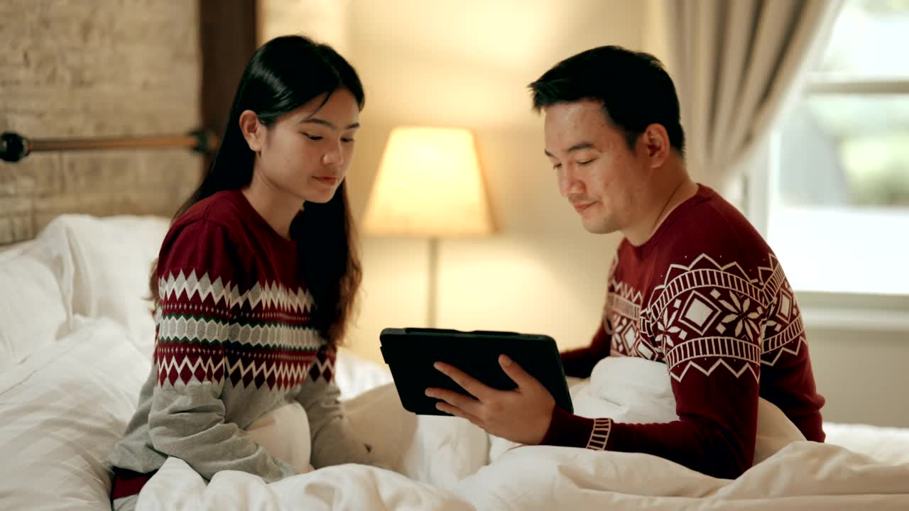 夫妻坐在床上在节日庆祝圣诞季节视频素材