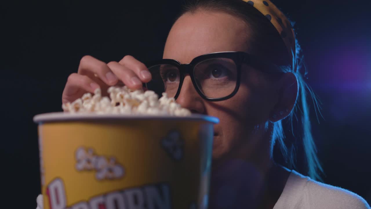 在电影院看电影吃爆米花的女人视频下载