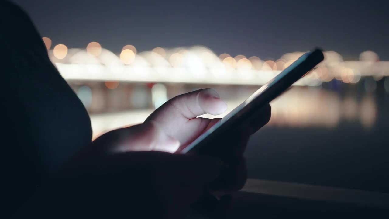 晚上在城市里使用智能手机的女人视频下载