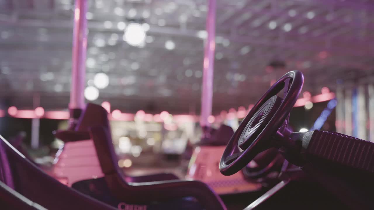 游乐园仍然拍摄的自卸车在闪烁的霓虹灯下前景和模糊的人视频素材