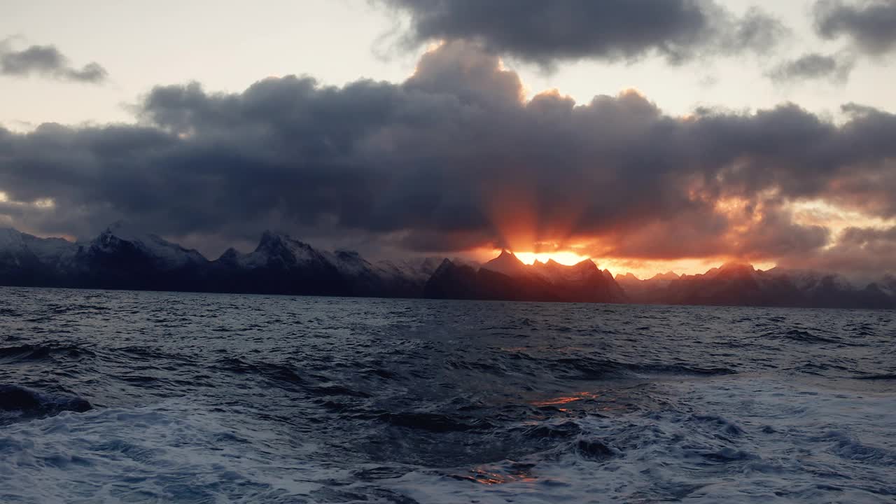 夕阳在波涛汹涌的海面上，带着一艘小船从开阔的大海上驶来视频下载
