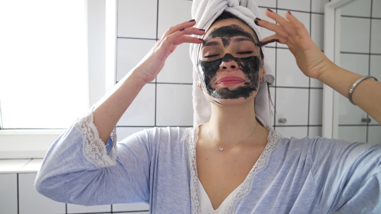 女性在面部涂抹黑色营养面膜视频下载