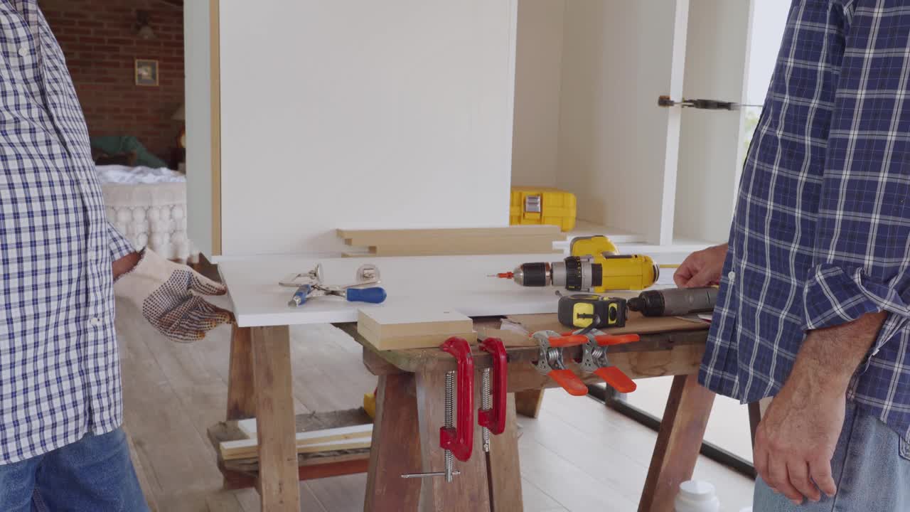 西班牙裔木匠为自己房子的厨房改造钻胶合板的特写视频下载