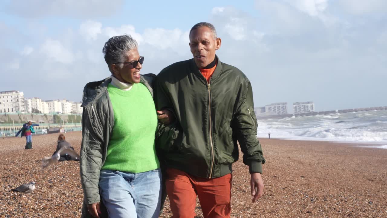 在海滩上散步的快乐的老夫妇视频素材