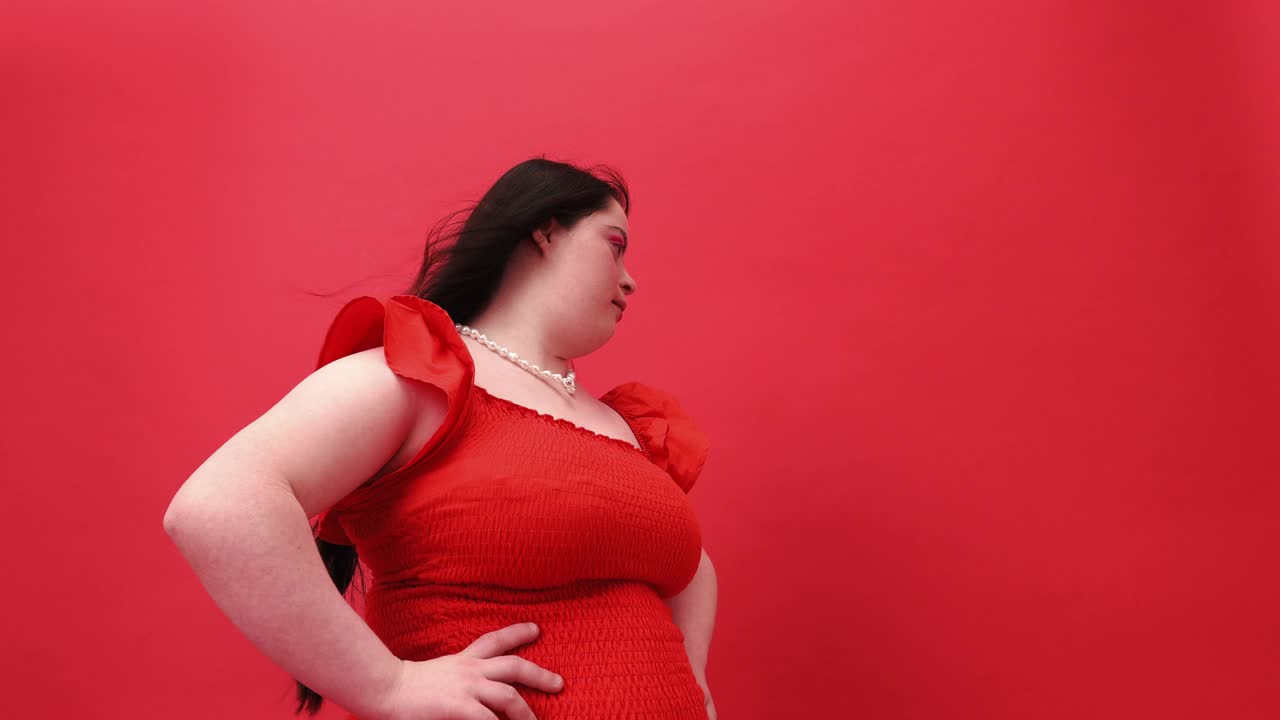 年轻女子身穿红色连衣裙，双手叉腰视频下载