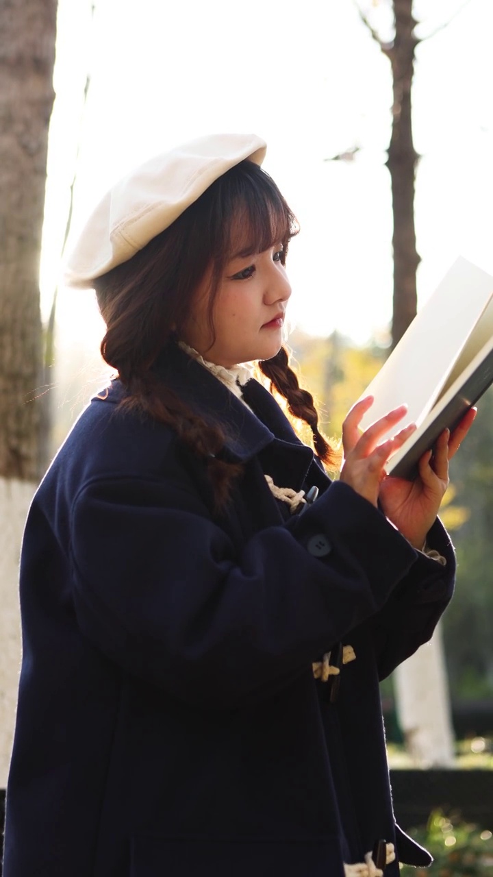 秋天，日落时分，一个女人在外面看书。视频素材