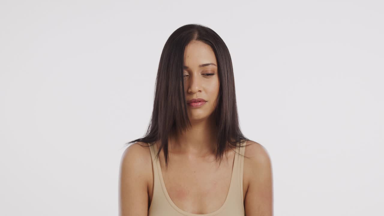 一个美丽的年轻女子把头发从脸上吹开的4k视频片段视频素材