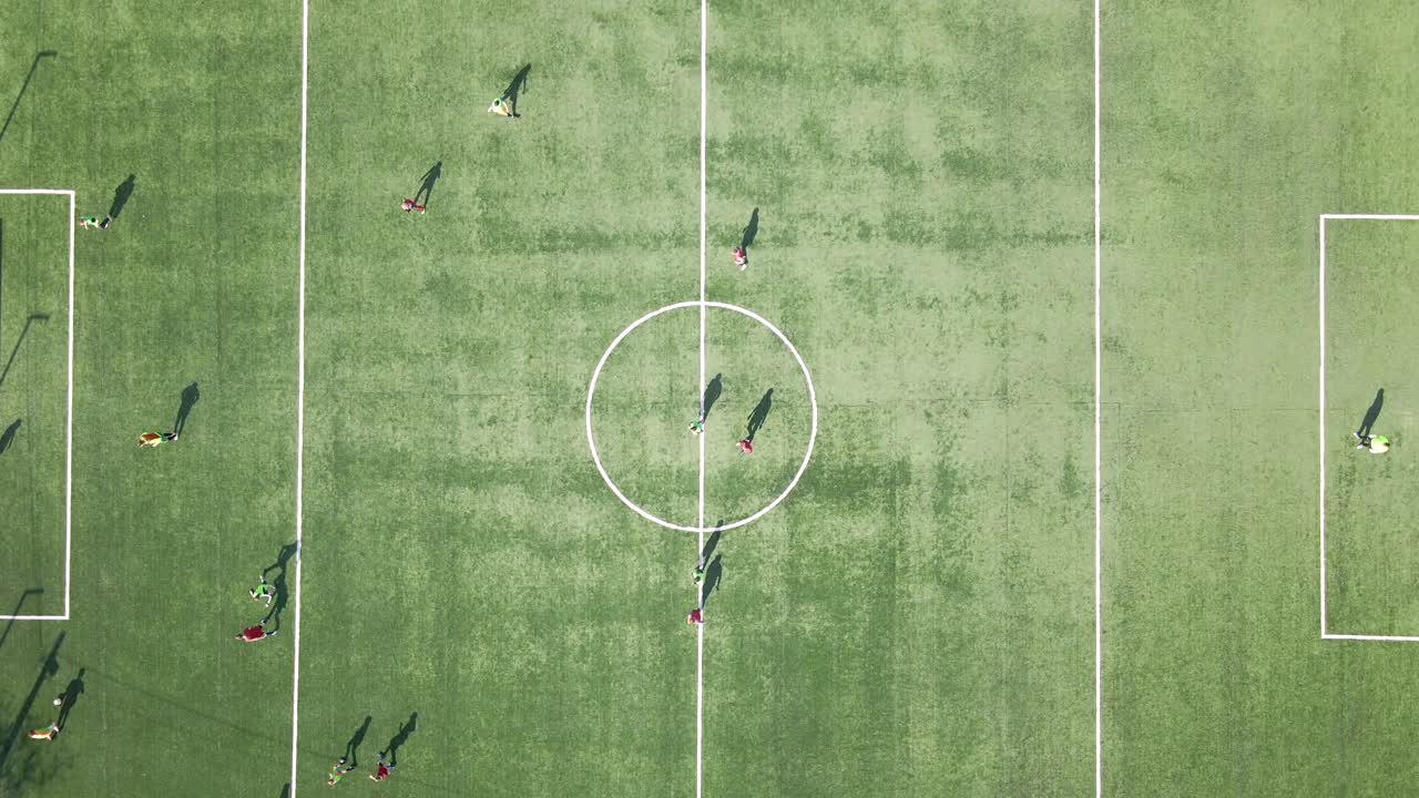 鸟瞰图足球运动员在绿色体育场踢足球视频素材