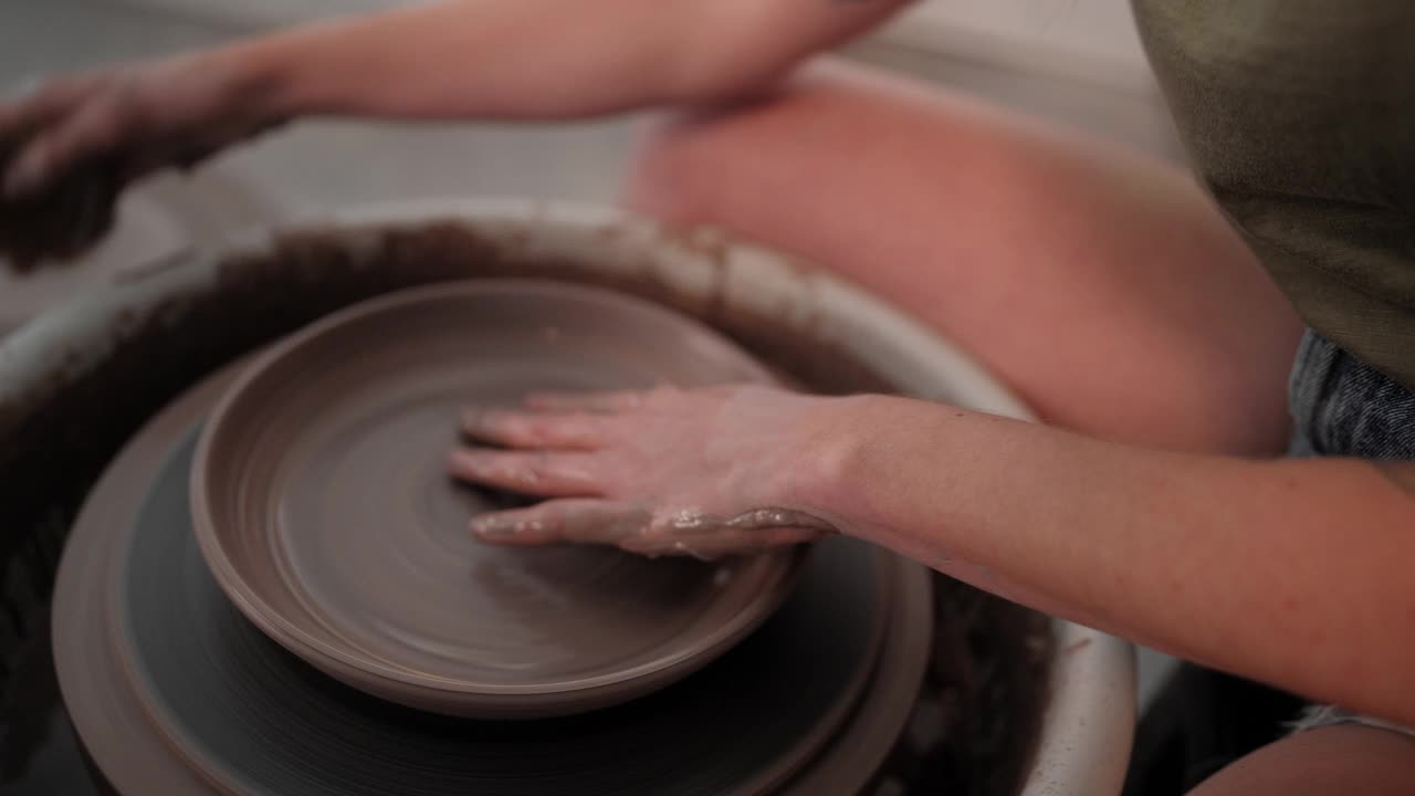 铜。女人用手指在陶轮上做碗视频素材