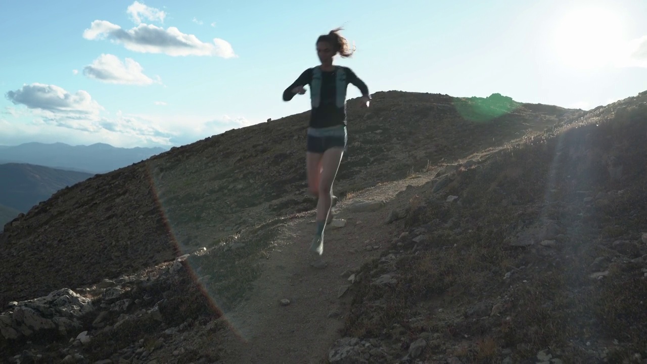 日落时分，女人在山间跑步。视频素材