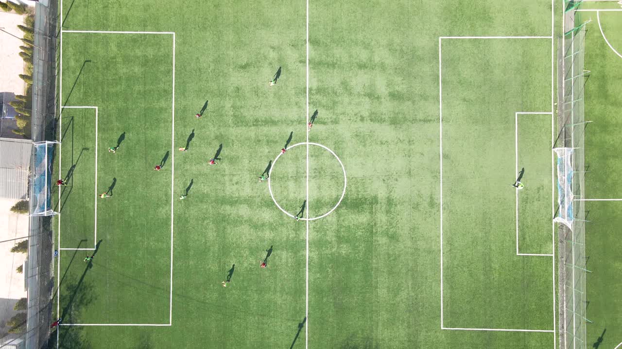足球运动员在绿色的体育场踢足球的鸟瞰图视频素材