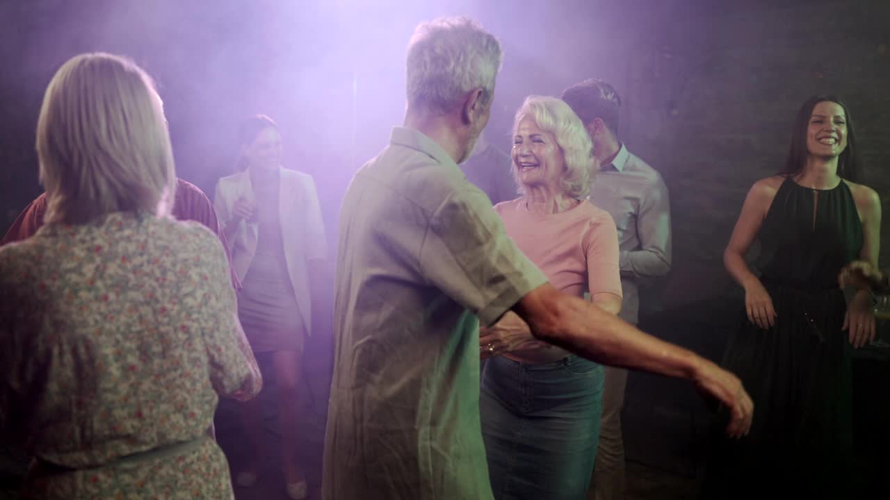 快乐的成熟夫妇在迪斯科舞厅跳舞。视频素材