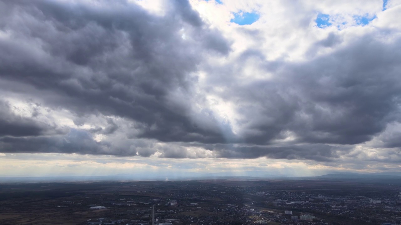 从高空的飞机窗口鸟瞰，远处的城市被暴雨前形成的蓬松的积云所覆盖视频素材
