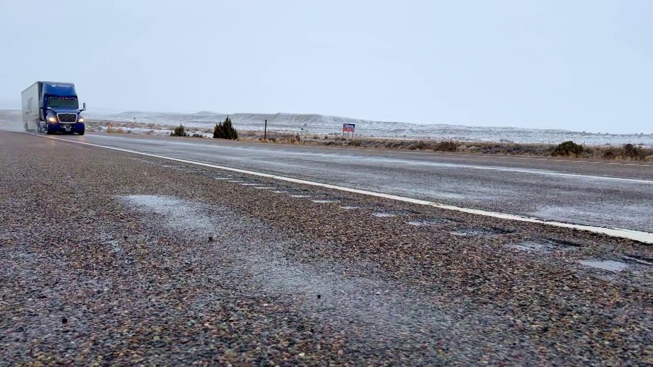 蓝色的半挂车在下雪的时候穿过犹他州边境视频素材