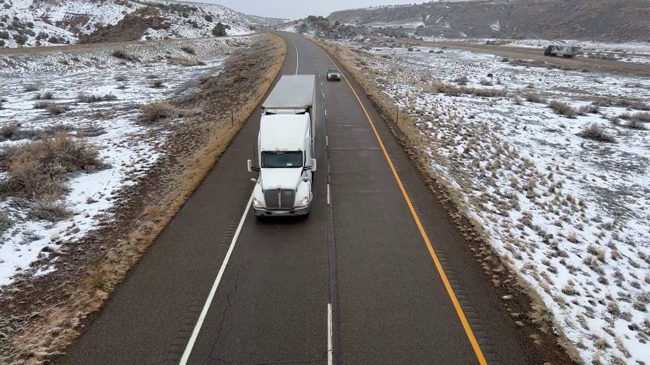 半卡车和车辆在高速公路的雪地上行驶视频素材
