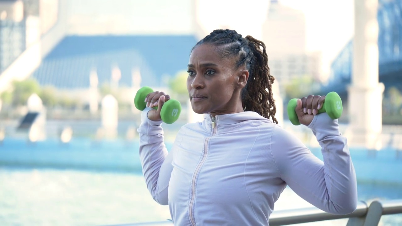 一个非裔美国妇女用哑铃健身视频素材