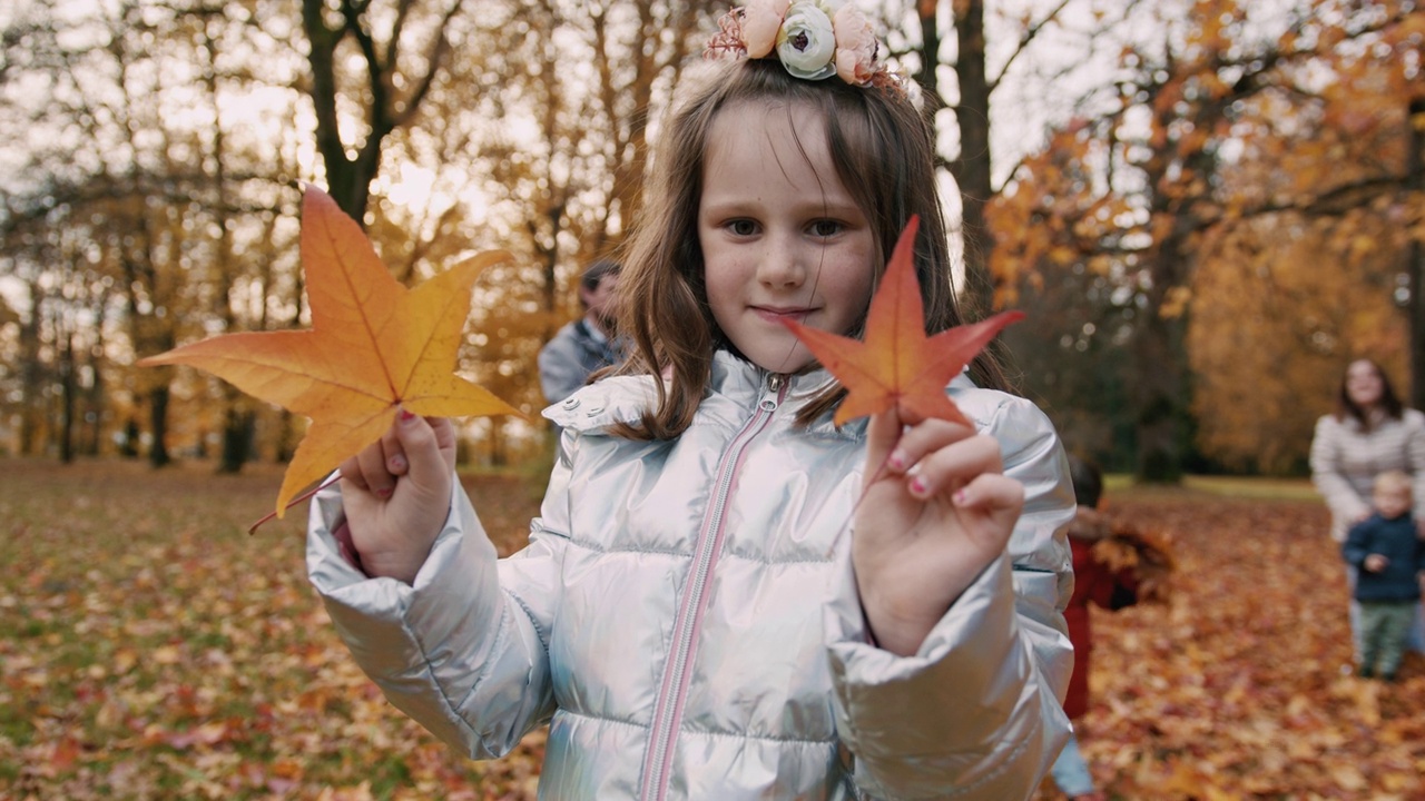 女孩在公园里捧着黄秋的落叶视频下载