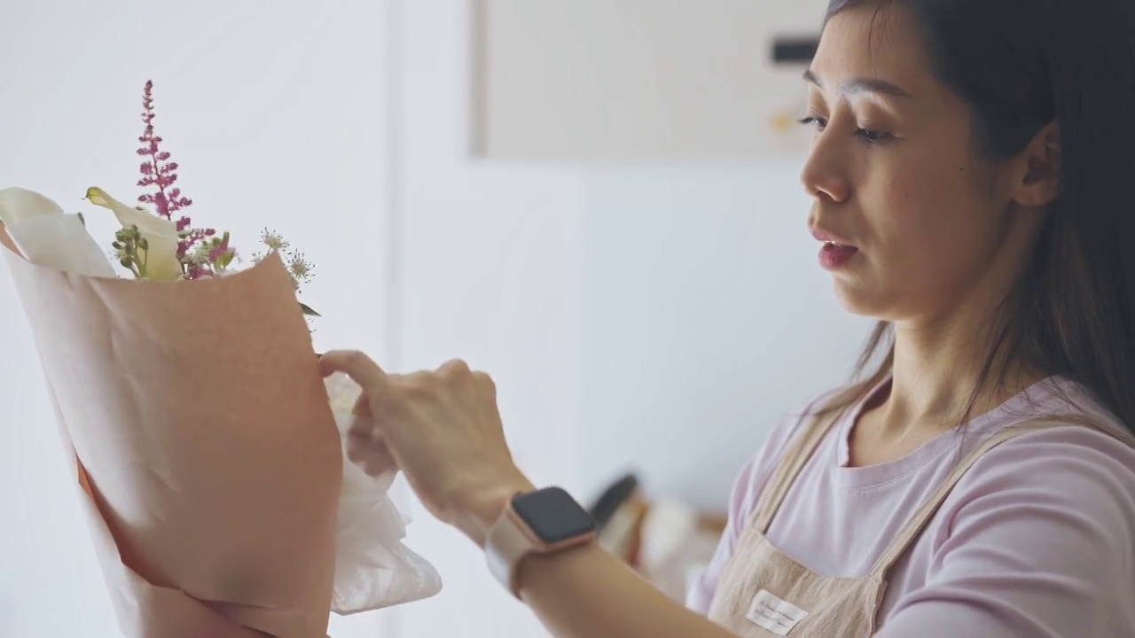 亚洲华人女性花商，小企业主包装花束在厨房工作，在家里运行一个小生意的日常工作视频素材