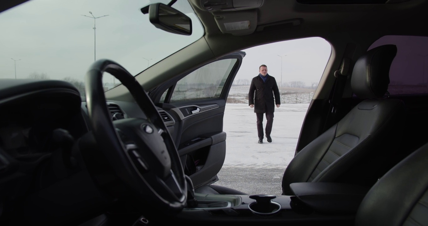 一个人在积雪的街道上走向他的汽车视频下载